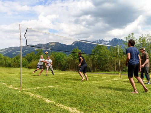 Volleyball auf der Wiese - am Netz stehen zwei Manschaften