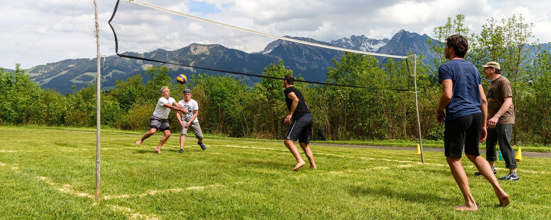 Volleyball auf der Wiese - am Netz stehen zwei Manschaften