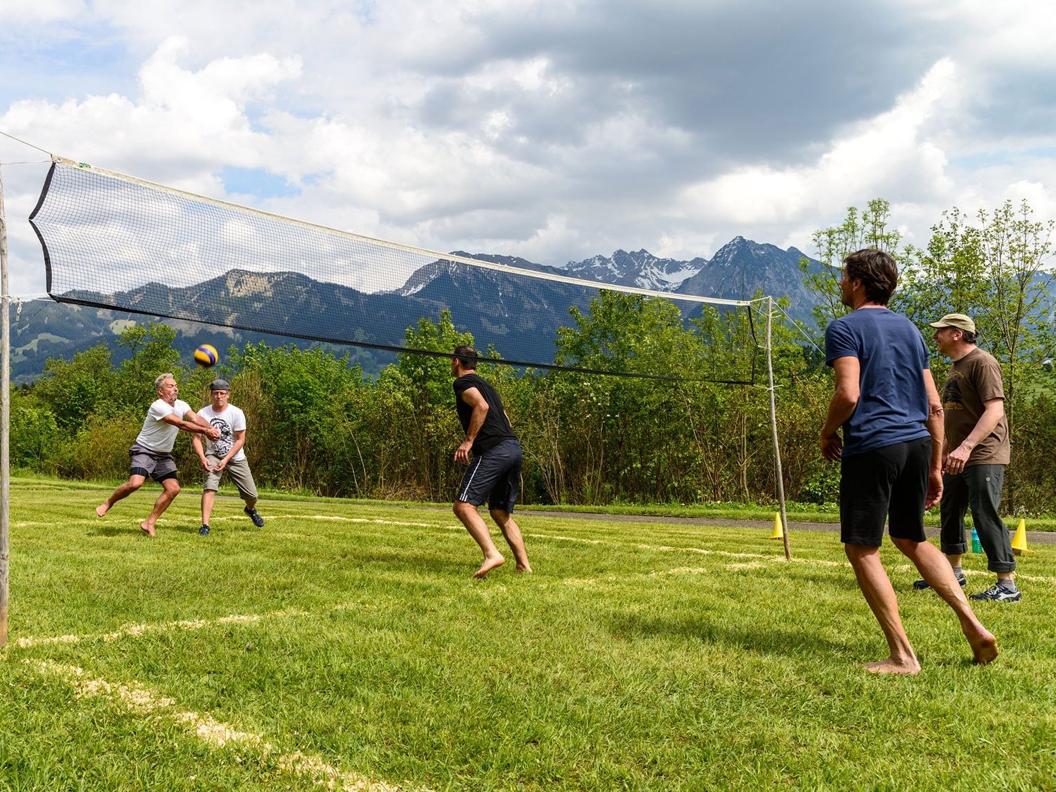 Volleyball auf der Wiese - am Netz stehen zwei Manschaften