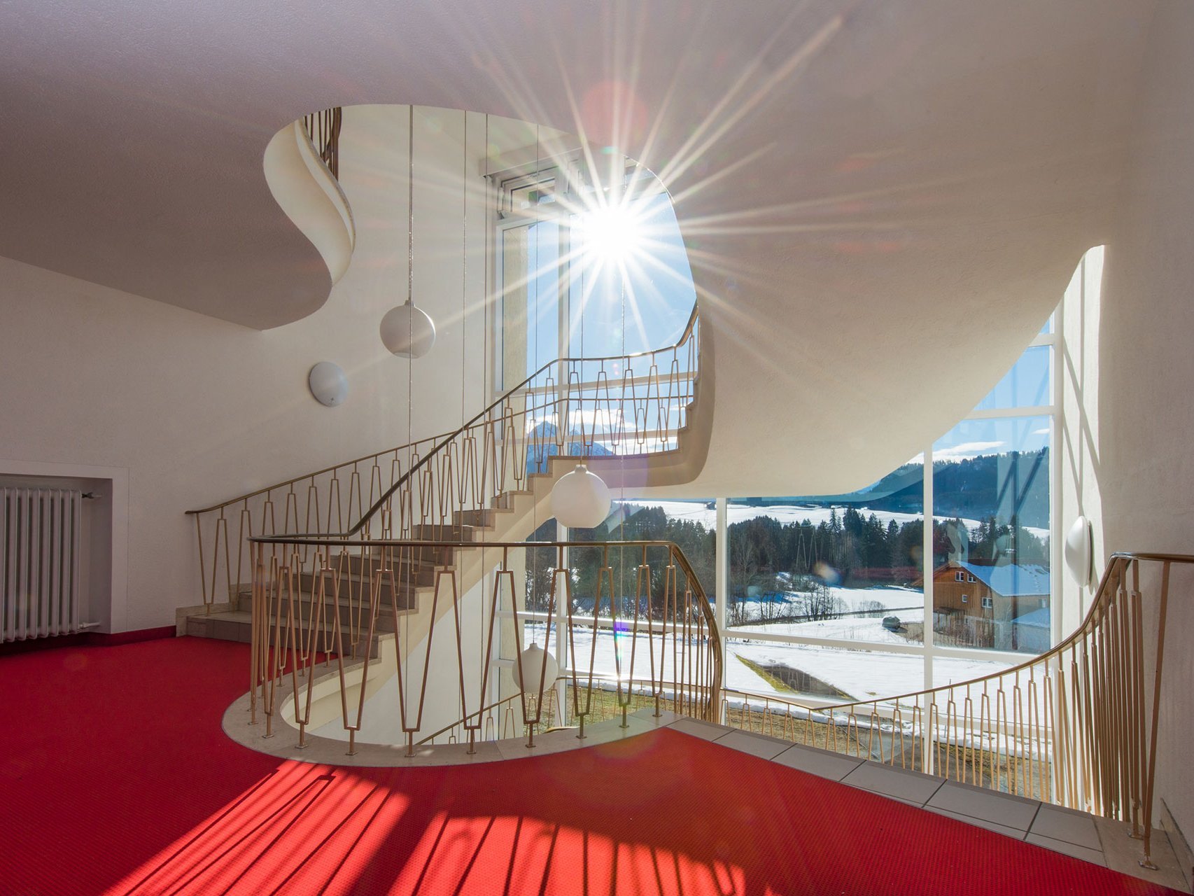 Treppenhaus der Suchtklinik - die Winterlandschaft bei Sonnenschein durch große Fenster gesehen