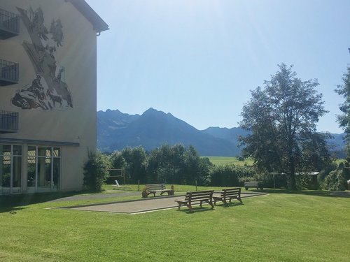 Aussenaufnahme der Suchthilfe - Gartenanlage mit Boggia-Sandkasten an dem Parkbänke stehen