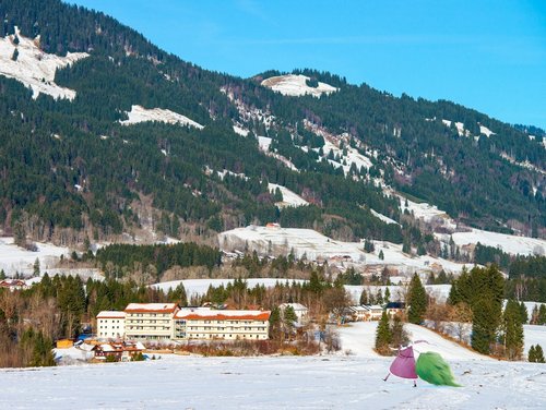 Aussenaufnahme: verschneite Suchthilfe und Berge im Hintergrund