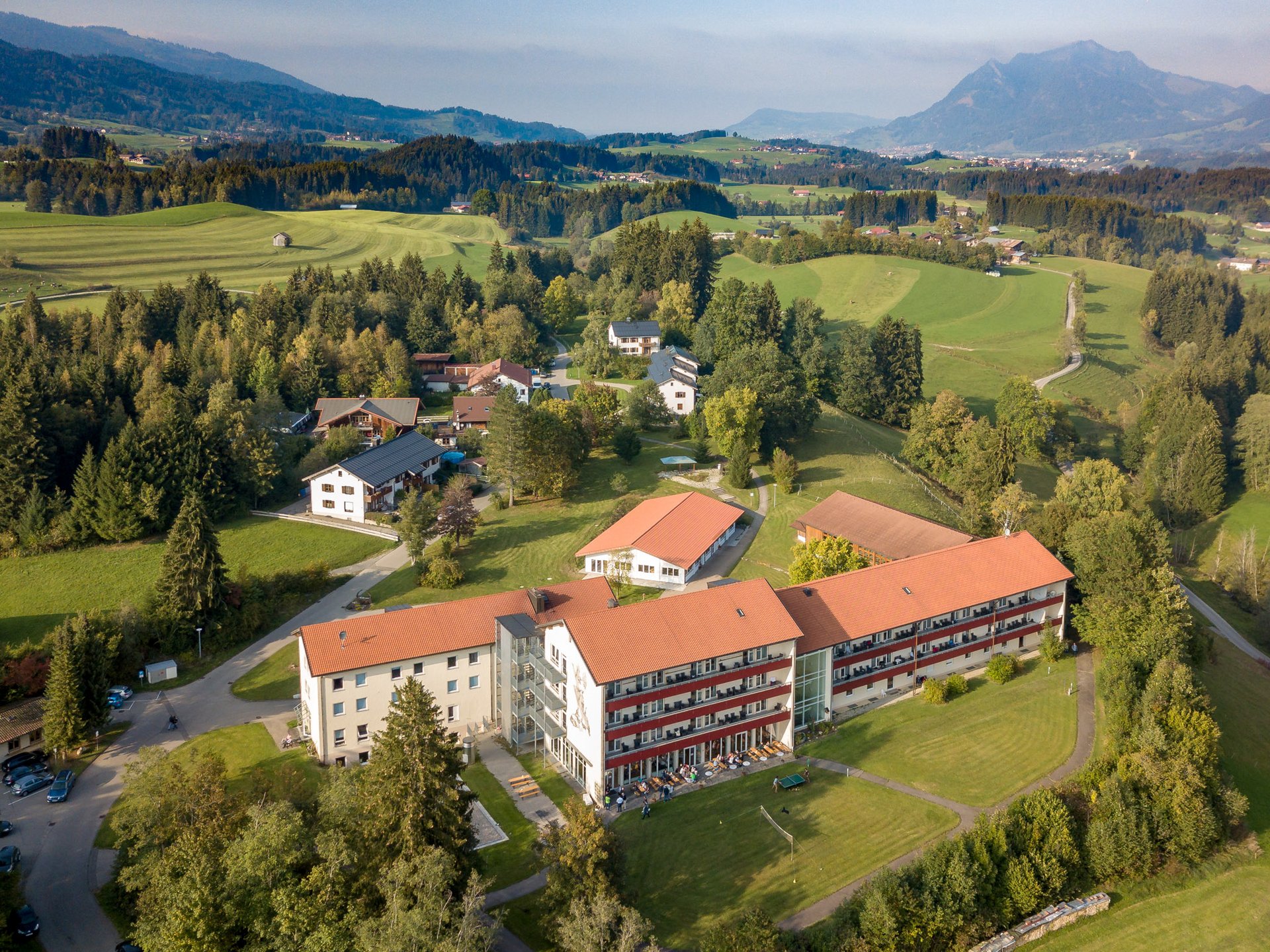 Luftbild der Suchtklinik Allgäu - grüne Wiesen, Bäume und Alpenpanorama